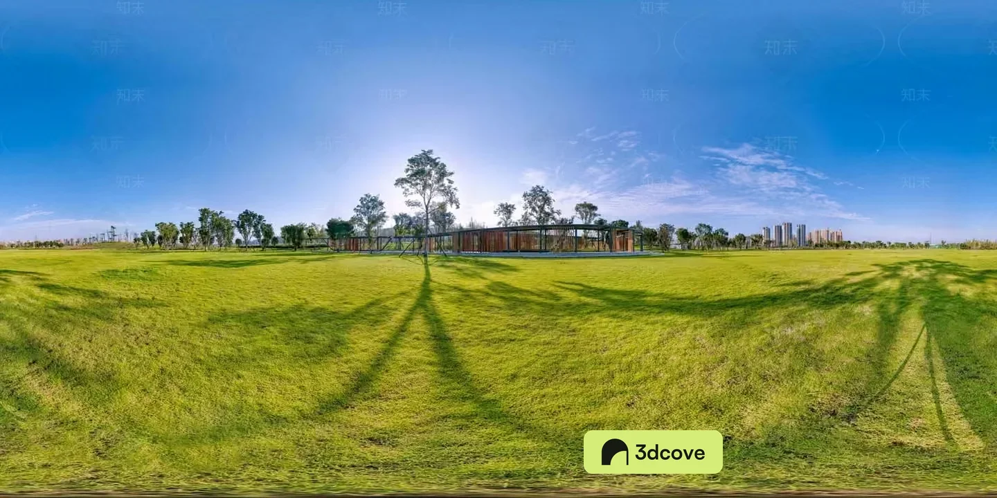A Grassy Field With Trees And A Building In The Background